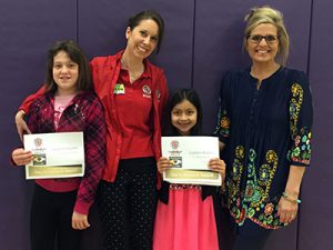 Katie Frassinelli of the NCM Motorsports Park and Museum presents T.C. Cherry Students Sabbath Hoehn and Gabbie Robles with #DayItForward awards.